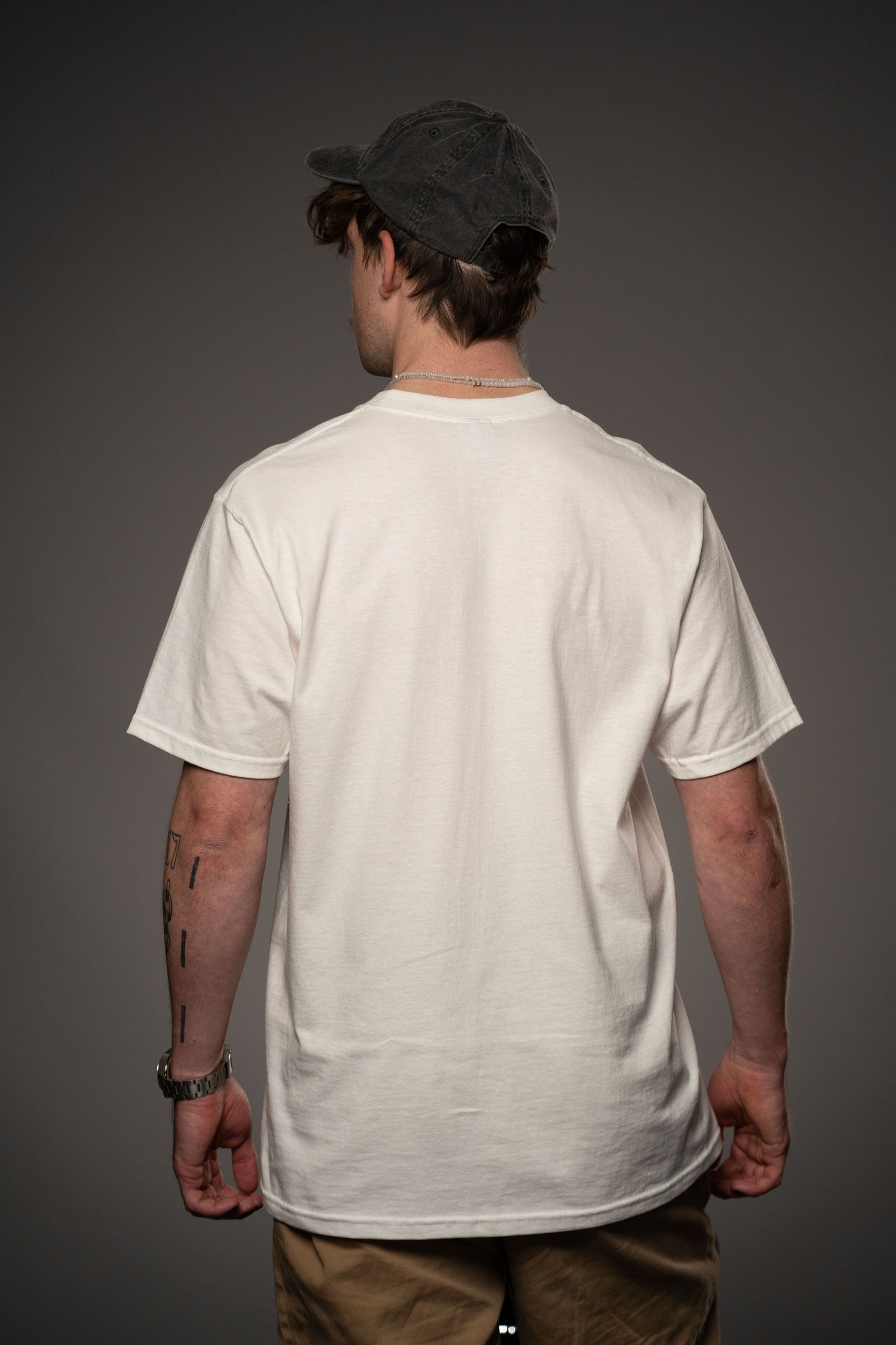 Rückansicht des weißen T-Shirts aus Baumwolle ohne Aufdruck. Der Fokus liegt auf der schlichten Rückseite und dem geraden Schnitt.