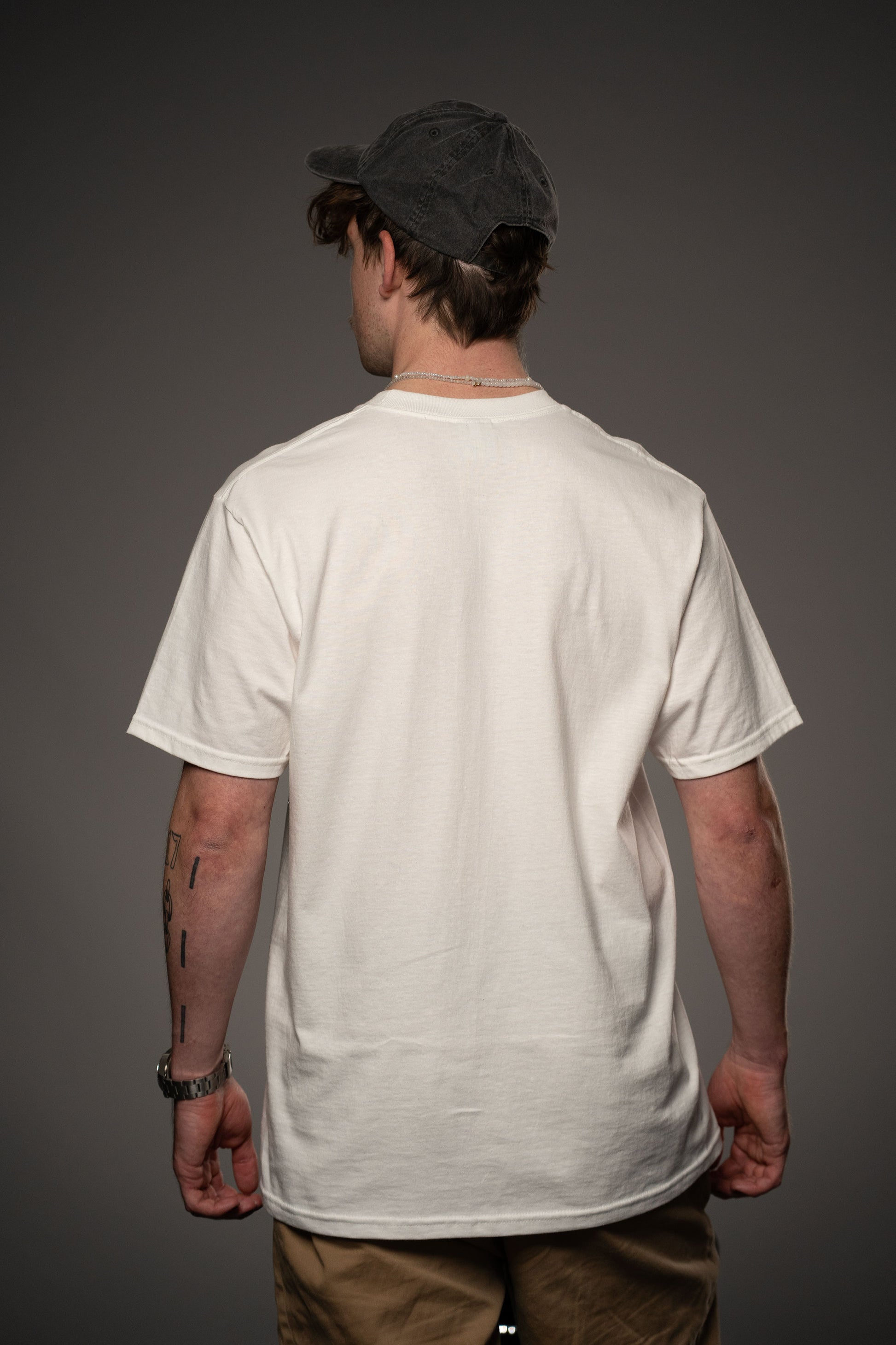 Rückansicht des weißen T-Shirts aus Baumwolle ohne Aufdruck. Der Fokus liegt auf der schlichten Rückseite und dem geraden Schnitt.